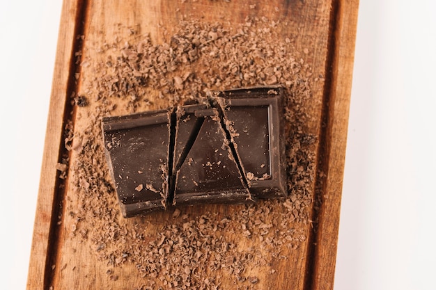 Шоколад между шоколадной стружкой на разделочной доске