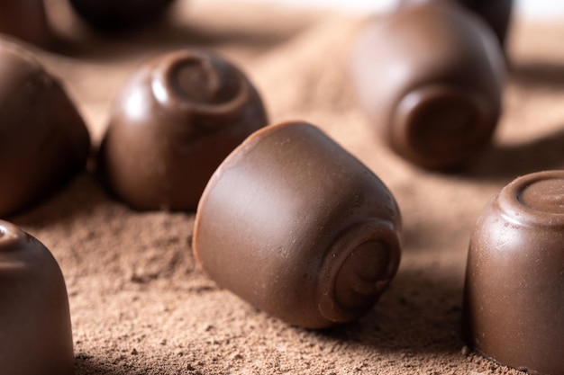 Foto gratuita cioccolatini al cioccolato e fondo di polvere di cacao primo piano