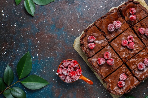 Chocolate brownie cake dessert slices with raspberries and spices,top view