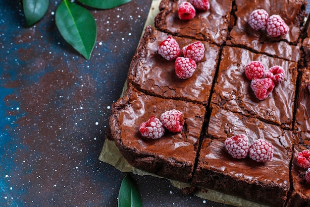 Chocolate brownie cake dessert slices with raspberries and spices, top view