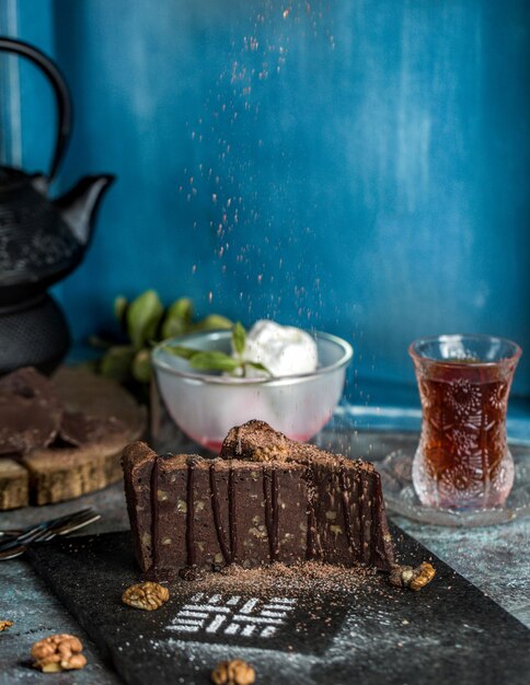 Chocolate brownie cake with ice cream balls and a glass of tea