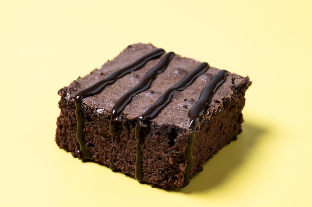 Chocolate brownie portion on yellow background