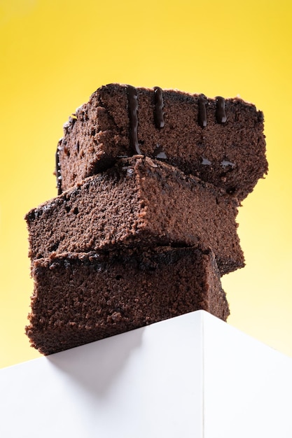 Бесплатное фото Порции шоколадного пирожного на желтом фоне