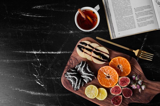 Chocolate brownies with seasonal fruits and a cup of tea.