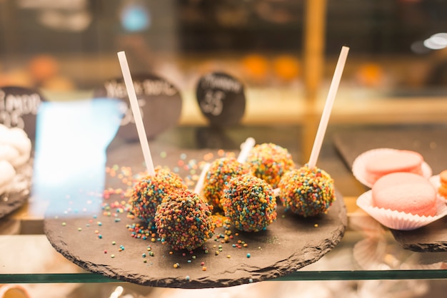 Chocolate cake pops with colorful sprinkles in the display cabinet