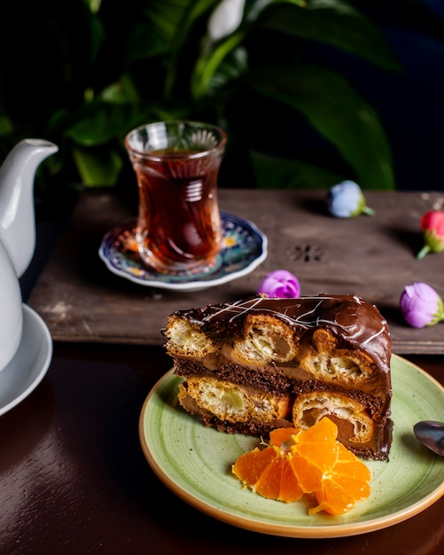 Chocolate cake served with orange slices and tea