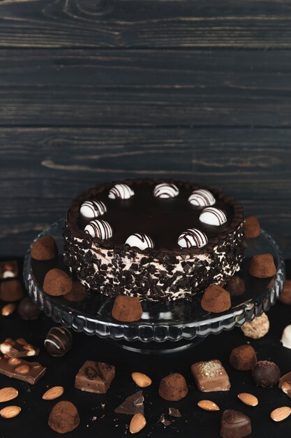 Шоколадный торт в окружении шоколадных трюфелей и конфет