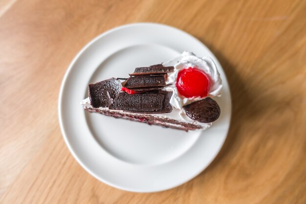 Chocolate cake with red cherries .