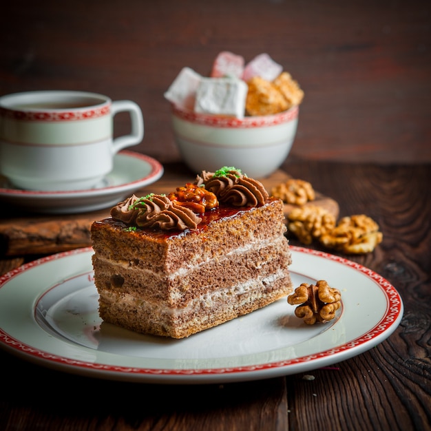 クルミとお茶と砂糖のカップの丸皿にチョコレートケーキ