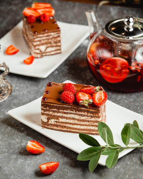 Foto gratuita torta al cioccolato con crema bianca cosparsa di cacao e frutti di bosco