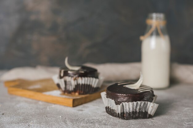 Chocolate cakes with milk bottle on concrete texture backdrop