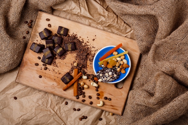 木製の机の上のチョコレート菓子シナモンとナッツ。