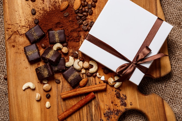 Шоколадные конфеты корица и орехи на деревянный стол.
