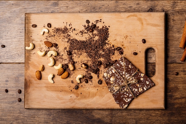 Foto gratuita caramelle di cioccolato cannella e noci su legno