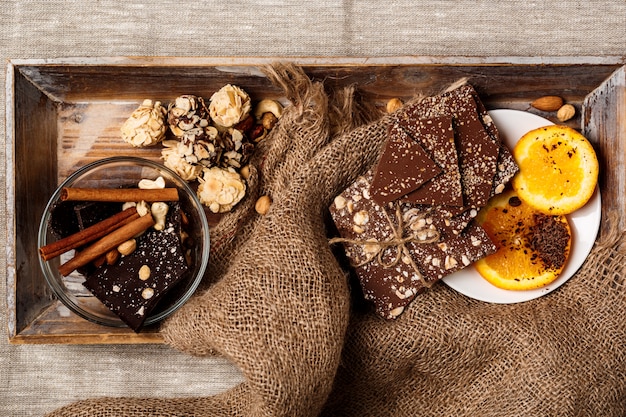 Chocolate candies cinnamon orange and nuts on sackcloth