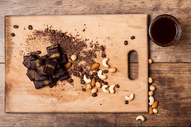 Chocolate candies coffee and nuts on wood