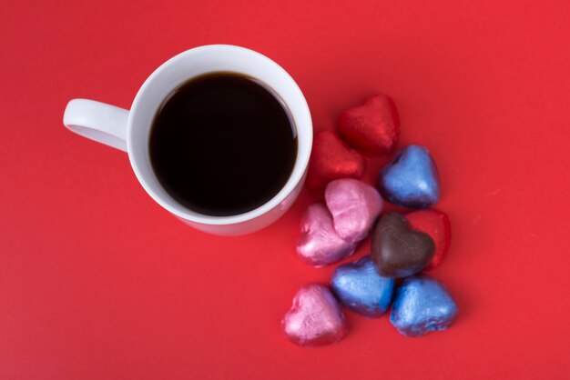 Chocolate candies in heart shape with coffee 