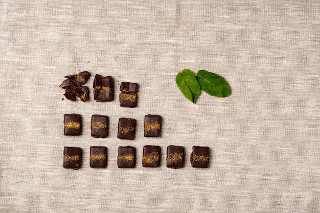 Free photo chocolate candies and mint on sackcloth