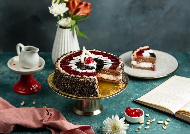 Chocolate cherry cake decorated with cherry and white glaze