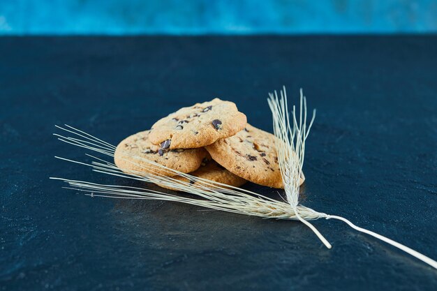 小麦の耳が付いている大理石の表面のチョコレートチップクッキー