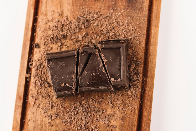 Chocolate between chocolate chips on chopping board 