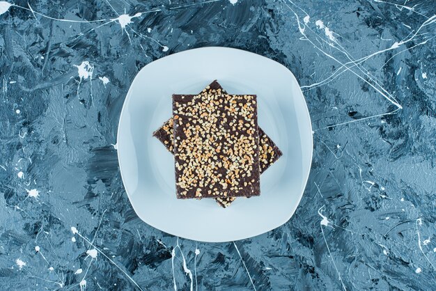 Chocolate coated waffle on a plate , on the blue table. 