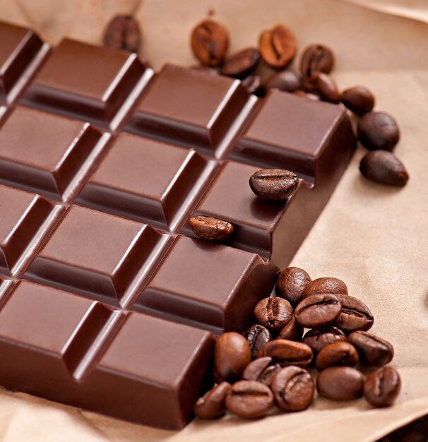 Шоколад и кофейные зерна на бежевой бумаге