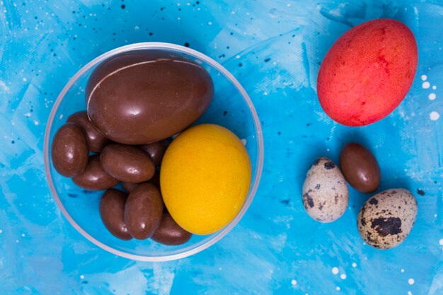 Chocolate and colorful Easter eggs on table