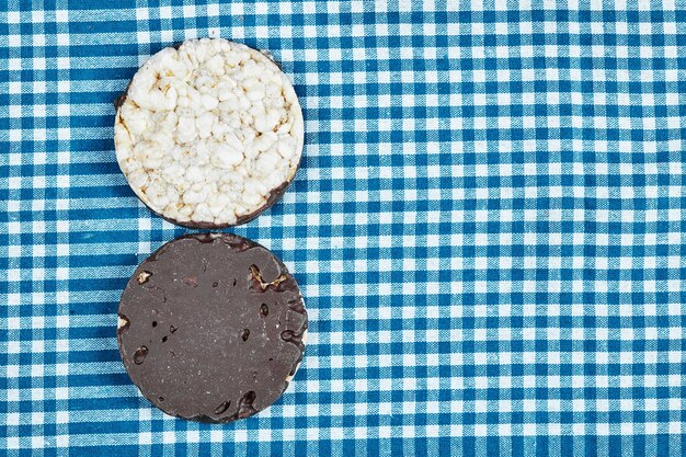 A chocolate cookie on a blue tablecloth.