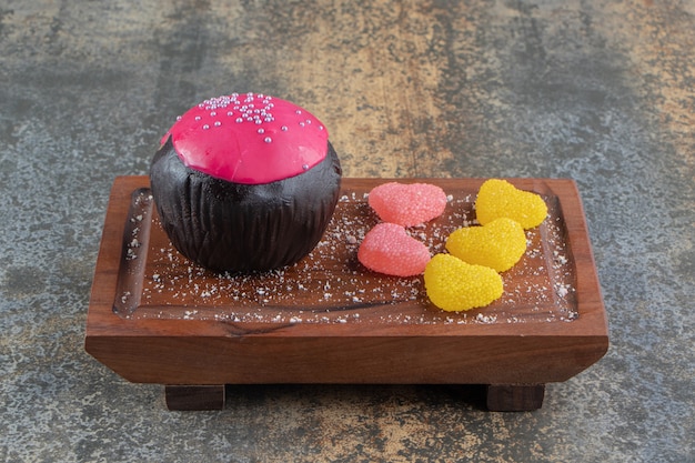 木の板にピンクの釉薬とキャンディーとチョコレートクッキー