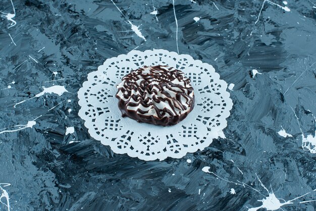 Foto gratuita biscotti al cioccolato su un sottobicchiere, sul tavolo blu.