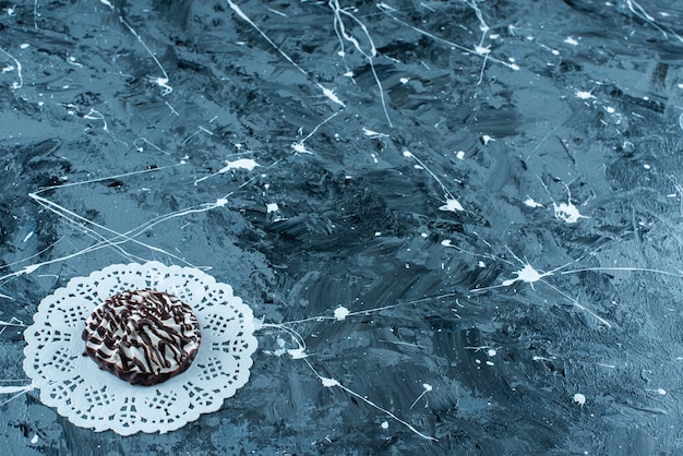 Chocolate cookies on a coaster, on the blue table.