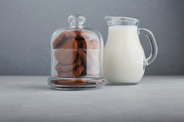 Chocolate cookies and a jar of milk. 