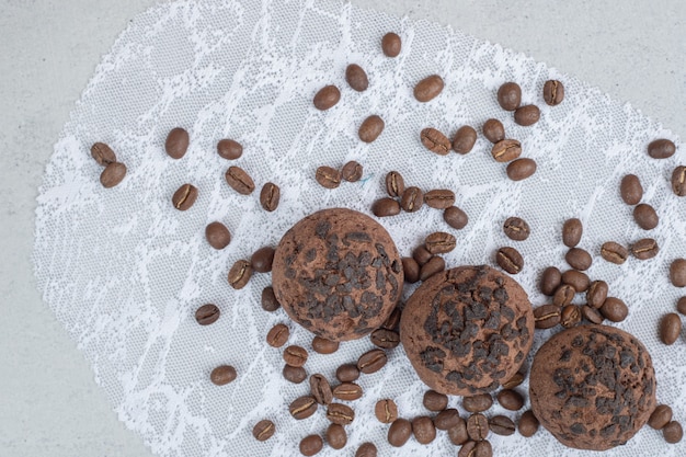 Biscotti al cioccolato con chicchi di caffè su superficie bianca