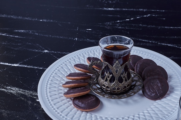 Chocolate cookies with a glass of tea. 