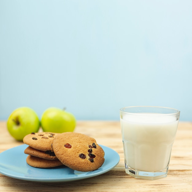 Foto gratuita biscotti al cioccolato con latte e mele sul tavolo