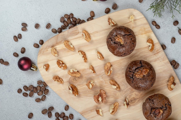 Chocolate cookies with walnuts and coffee beans with christmas ball on wooden board.