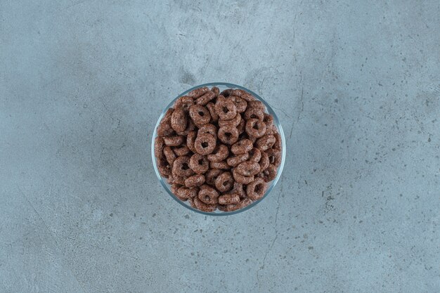 Chocolate corn ring in a glass pedestal , on the blue background.