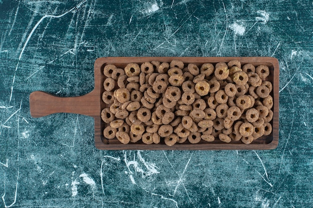 Chocolate corn rings on a board , on the blue background. High quality photo