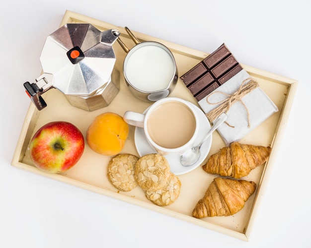 Chocolate, croissant, apple, cookie, milk and tea for breakfast