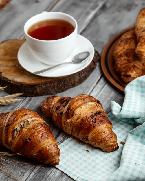 chocolate croissant with cup of teon table