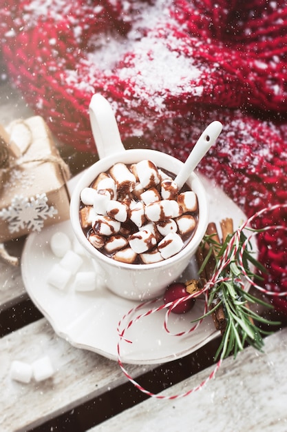 Chocolate cup with marshmallows and christmas decorations seen from above