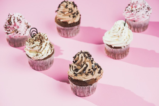 Chocolate cupcake with chocolate butter cream swirl on pink background