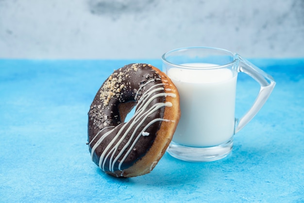 블루 테이블에 우유 한 잔과 초콜릿 도넛.