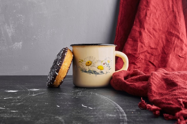 Foto gratuita ciambella al cioccolato con una tazza di tè.