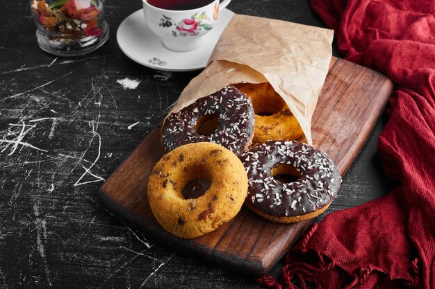 Chocolate doughnuts and buns on a wooden board. 