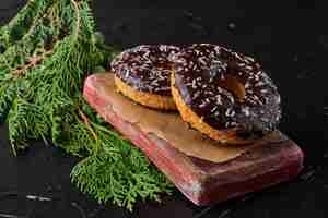 Бесплатное фото Шоколадные пончики на деревянной доске.