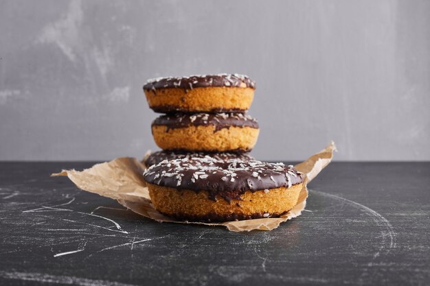 Chocolate doughnuts on a piece of paper. 