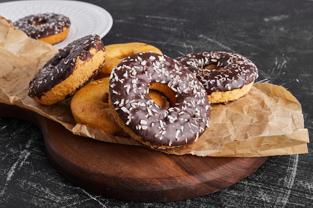 Chocolate doughnuts on a rustic platter. 