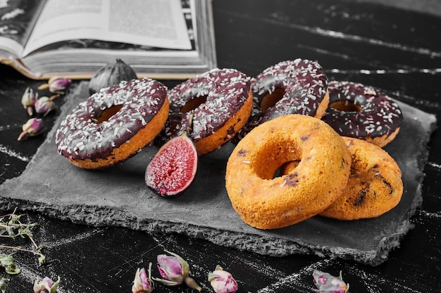 Chocolate doughnuts on a stone platter.